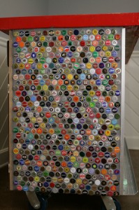 Full view of one side of the recycled bottle cap collection bar. 